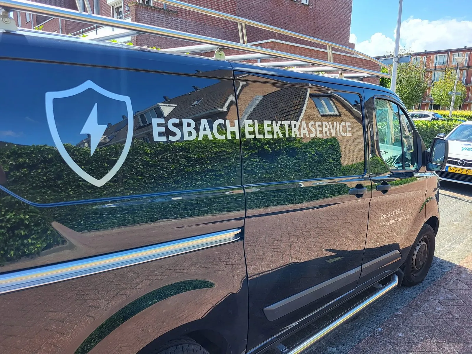 De bedrijfsbus van Esbach Service met logo en belettering